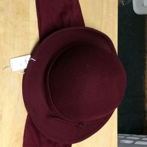 A burgundy hat with hear scarf attached
